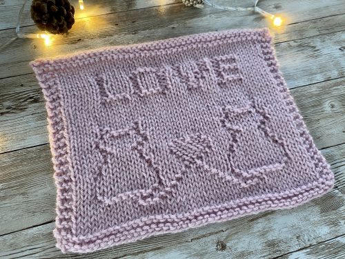 The finished Cat's Love square on a wooden surface