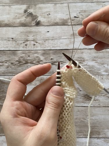 Step-by-step tutorial image demonstrating one of three techniques for threading beads onto yarn for knitting: using a hook, dental floss or thread, or pre-threading. The image shows the tools, materials, and process clearly to guide the viewer through the technique.