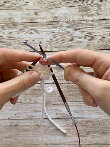Step-by-step tutorial image demonstrating one of three techniques for threading beads onto yarn for knitting: using a hook, dental floss or thread, or pre-threading. The image shows the tools, materials, and process clearly to guide the viewer through the technique.