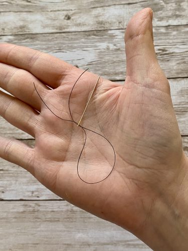 Step-by-step tutorial image demonstrating one of three techniques for threading beads onto yarn for knitting: using a hook, dental floss or thread, or pre-threading. The image shows the tools, materials, and process clearly to guide the viewer through the technique.