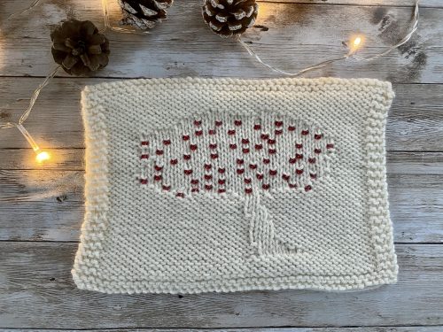 The finished Apple Tree Square with Red Beads as apples on a wooden surface