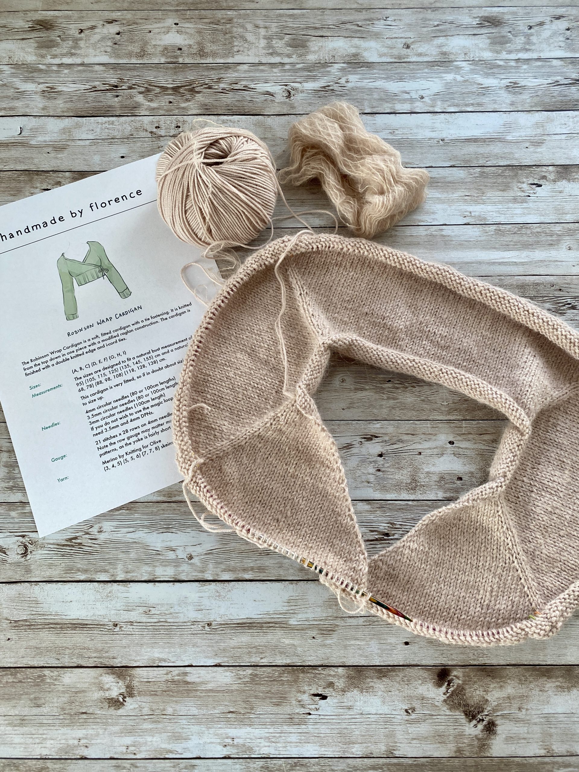 A partially completed Robinson Wrap Cardigan in a soft beige color.