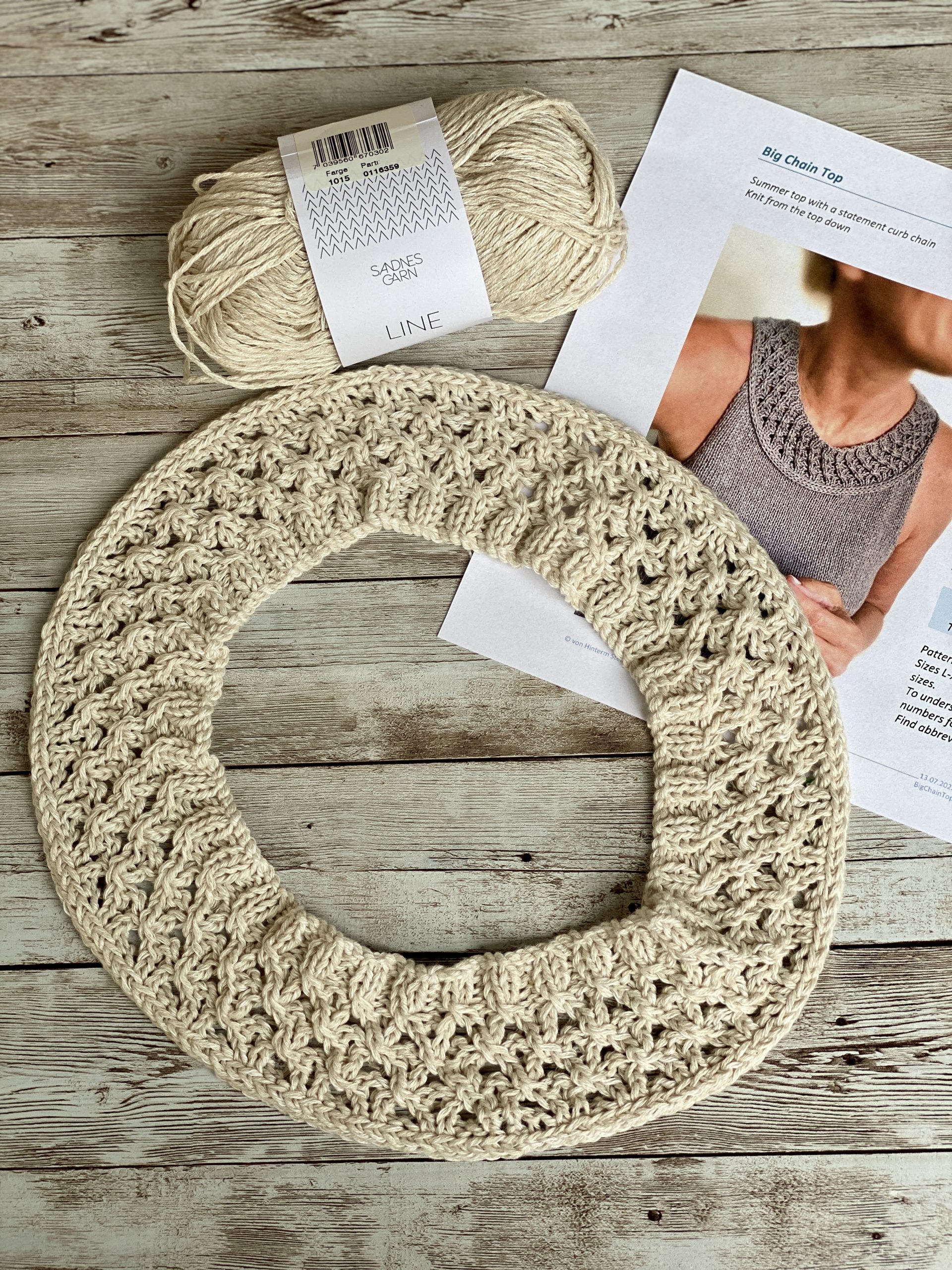 A partially completed Big Chain Top designed by Hinterm Stein, displayed on a wooden surface