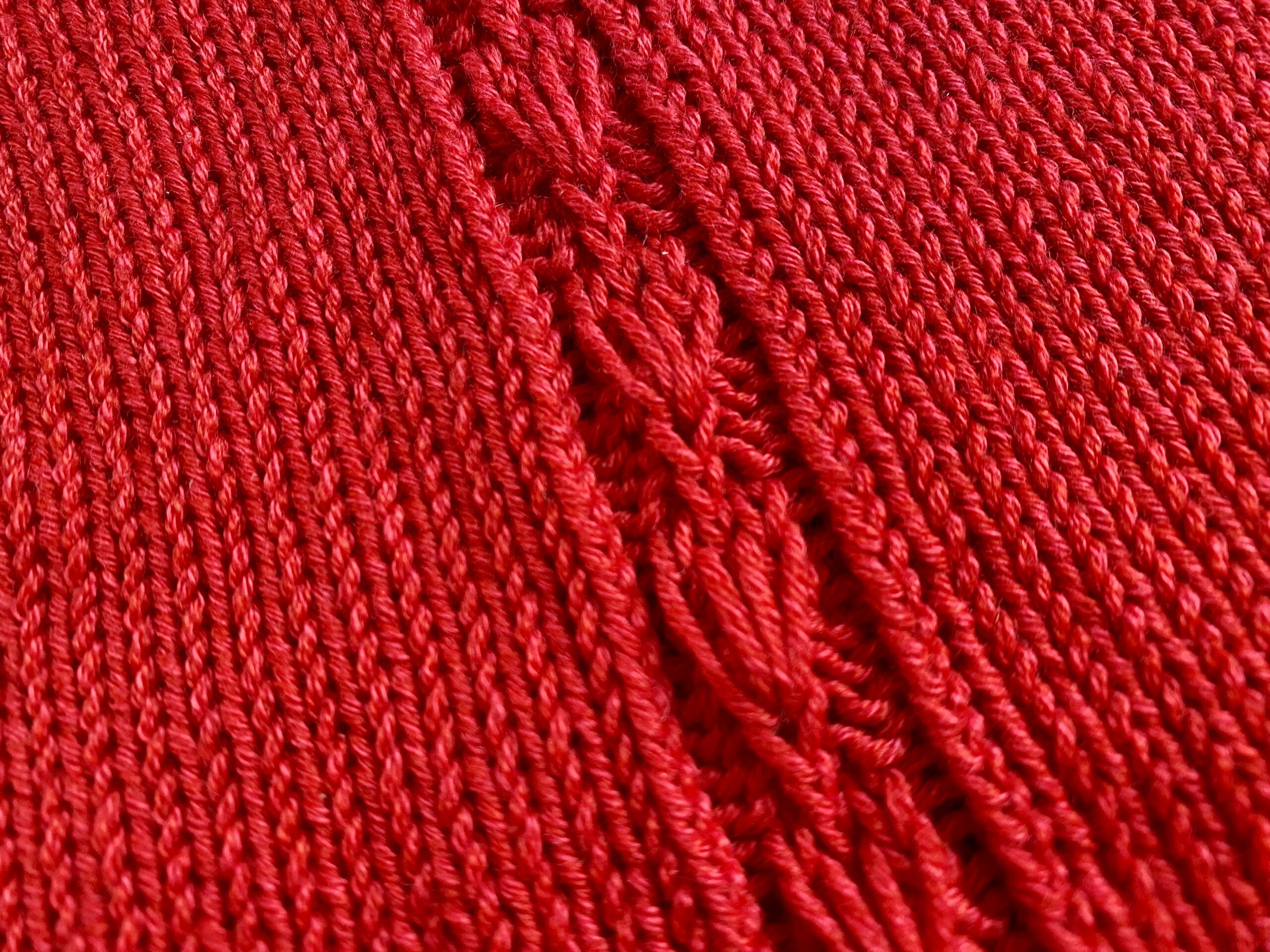 A close-up of the central lace panel of the Ginkgo Biloba Top, showcasing the intricate leaf-like pattern in vibrant red yarn.