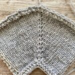 Close-up of knit swatches on wooden table in grey