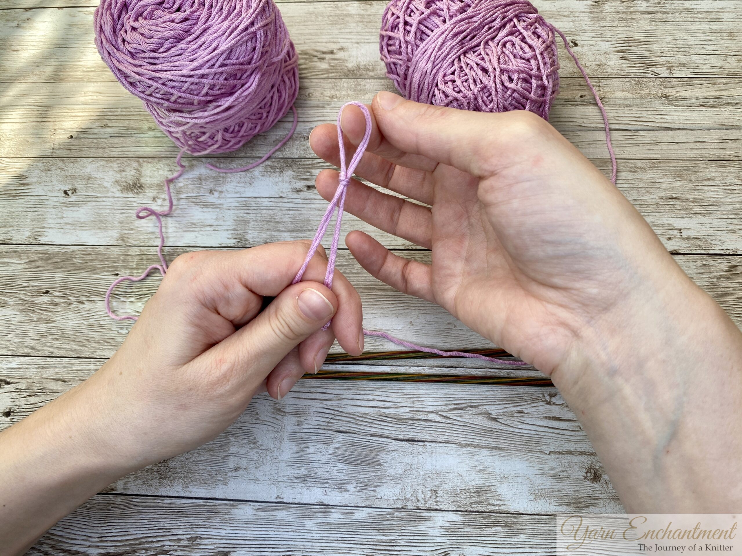 Hands tying a slip knot with pink yarn, preparing to start the long-tail cast-on method.