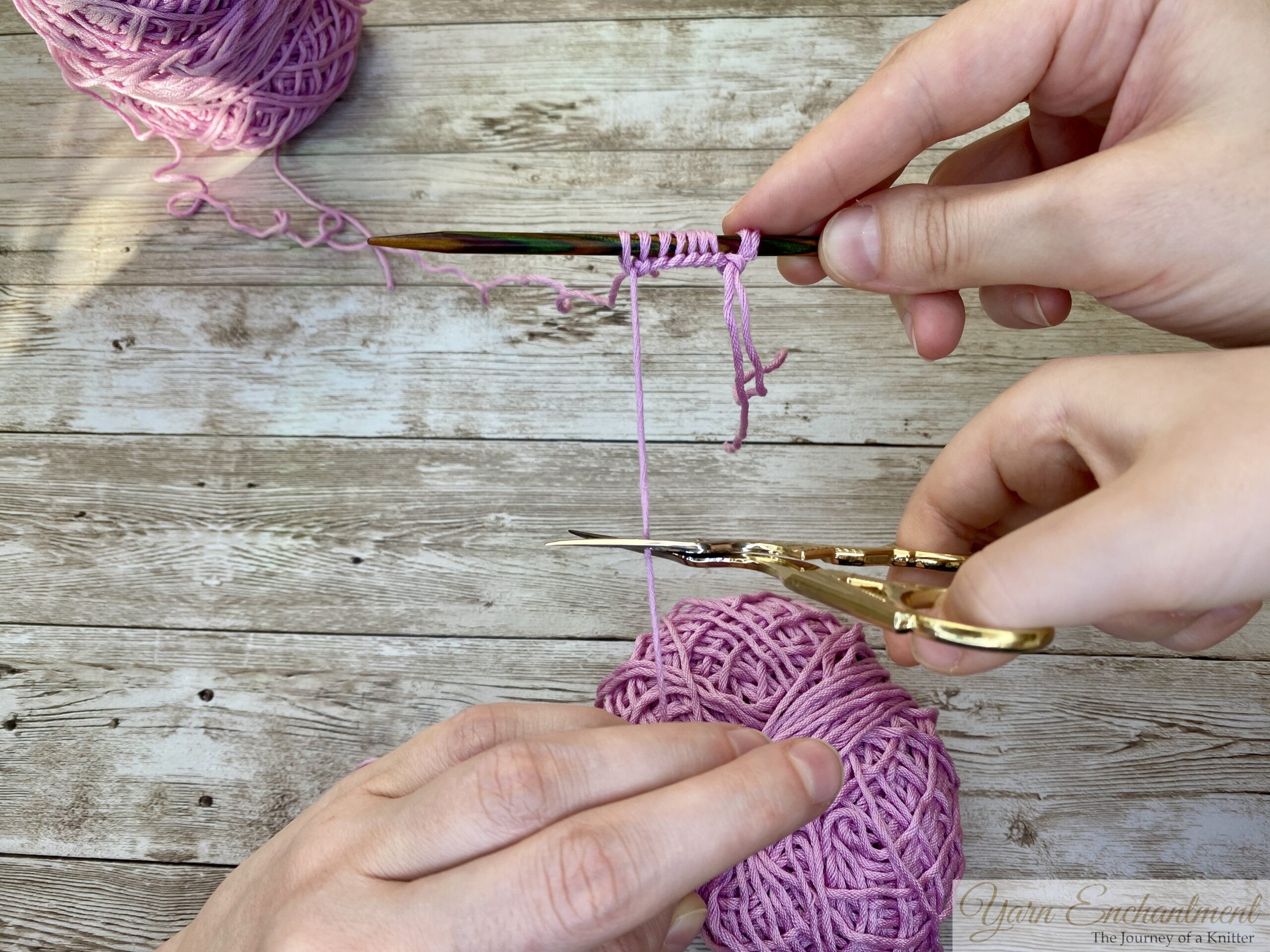 Close-up of pink yarn tails after casting on, ready to be trimmed and woven in.