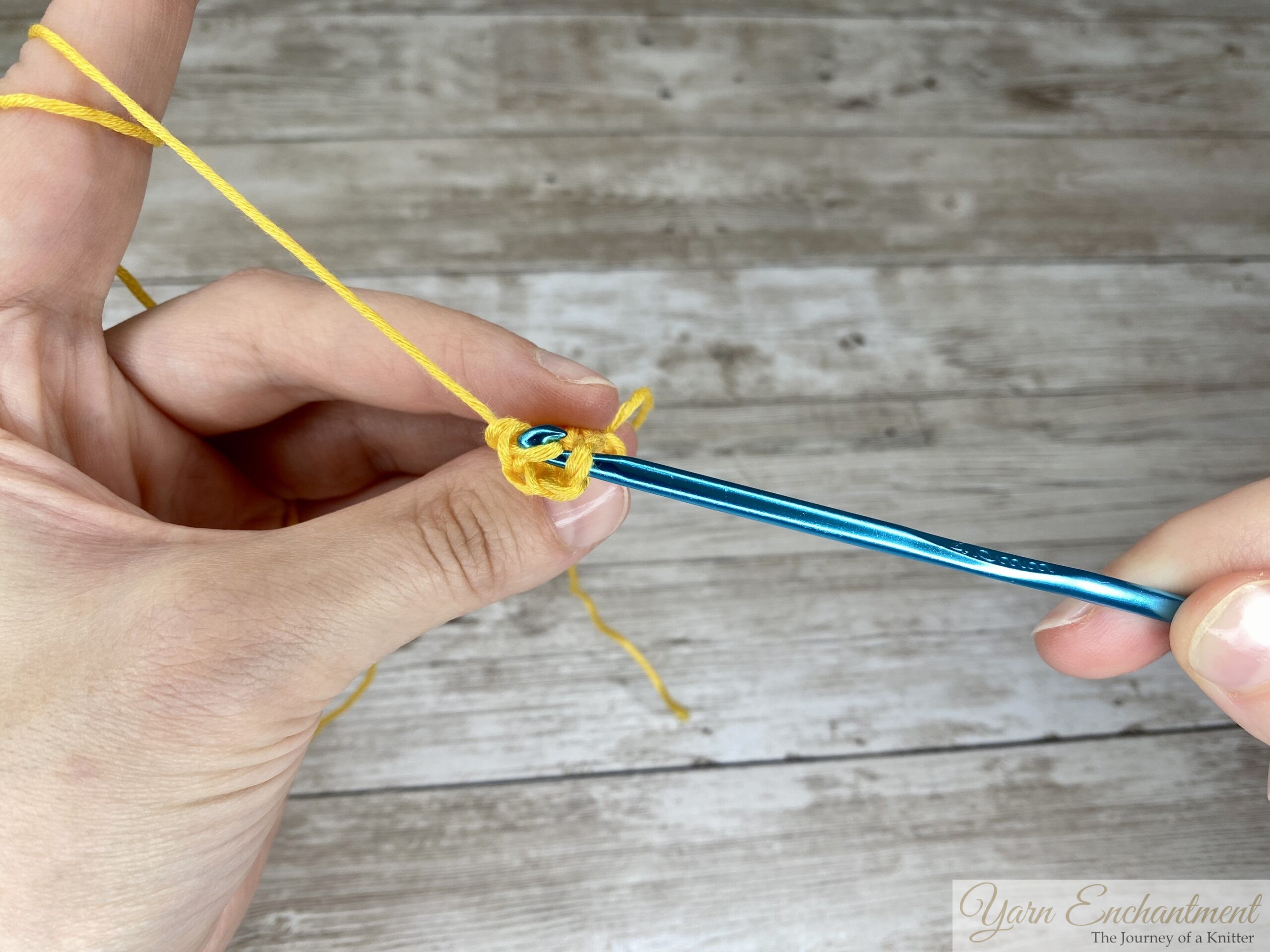 Hook pulling the yarn through both the loop and chain-3 space in a slip stitch, tightening the popcorn stitch.
