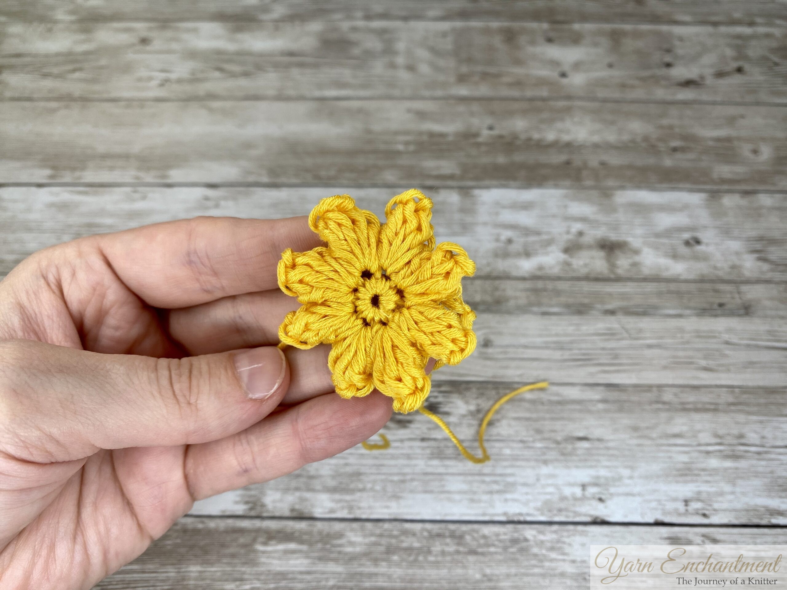 Close-up of the 3D flower granny square, highlighting the raised petals and intricate stitching