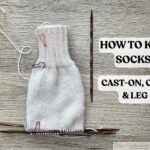 Cream colored sock knitted with double pointed needles showing completed ribbed cuff and stockinette leg section for beginner sock knitting tutorial