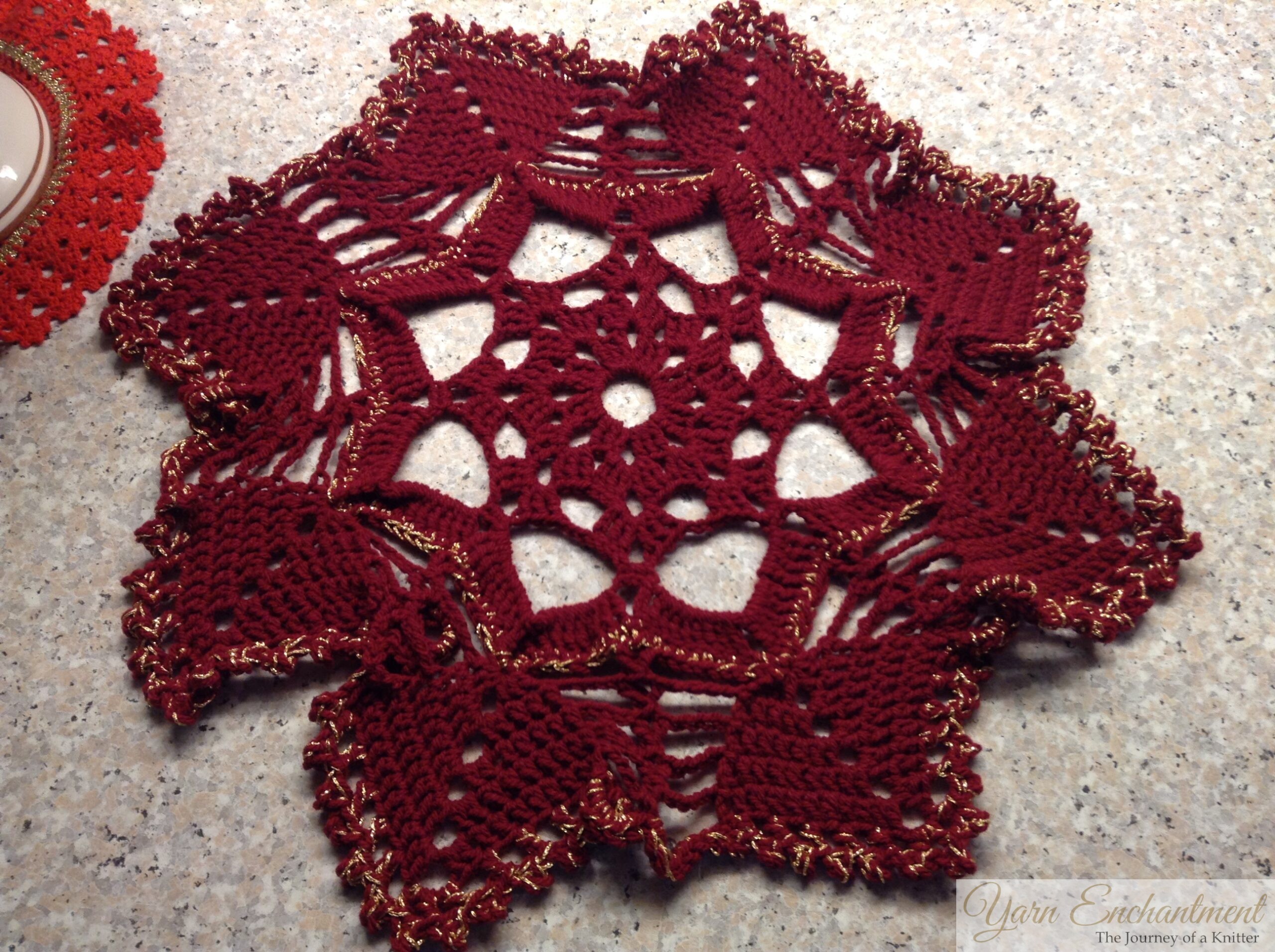Deep red handmade crochet tablecloth with gold accents, finished and donated to a Christmas bazaar for charity.