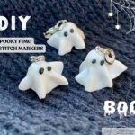 Handmade spooky Fimo clay ghost stitch markers displayed on dark knitted fabric, perfect for Halloween knitting projects and DIY craft tutorials
