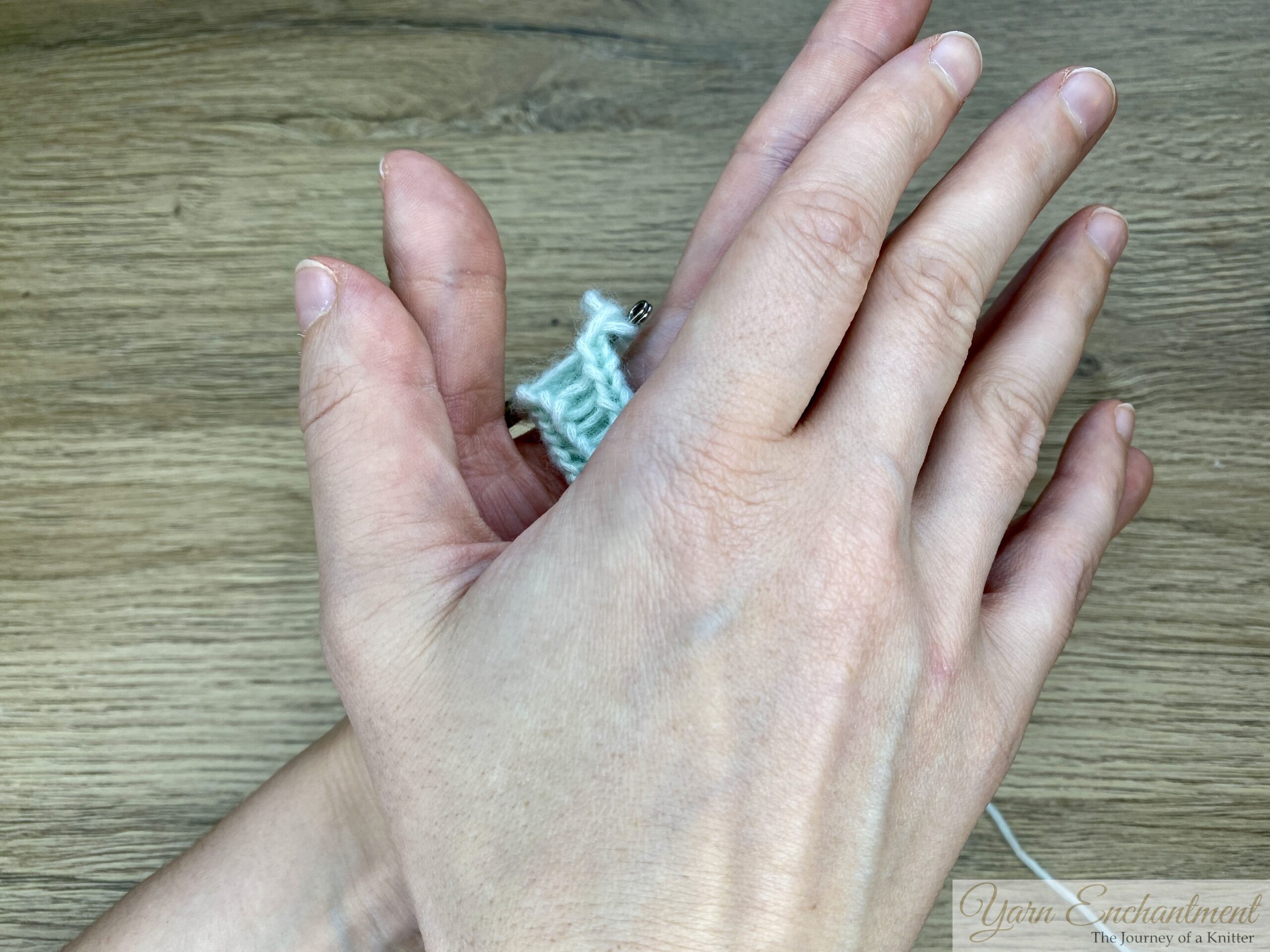 Both hands are rolling and slightly pressing the I-cord together, demonstrating the rolling technique that helps close the tube and create a smooth, rounded finish.