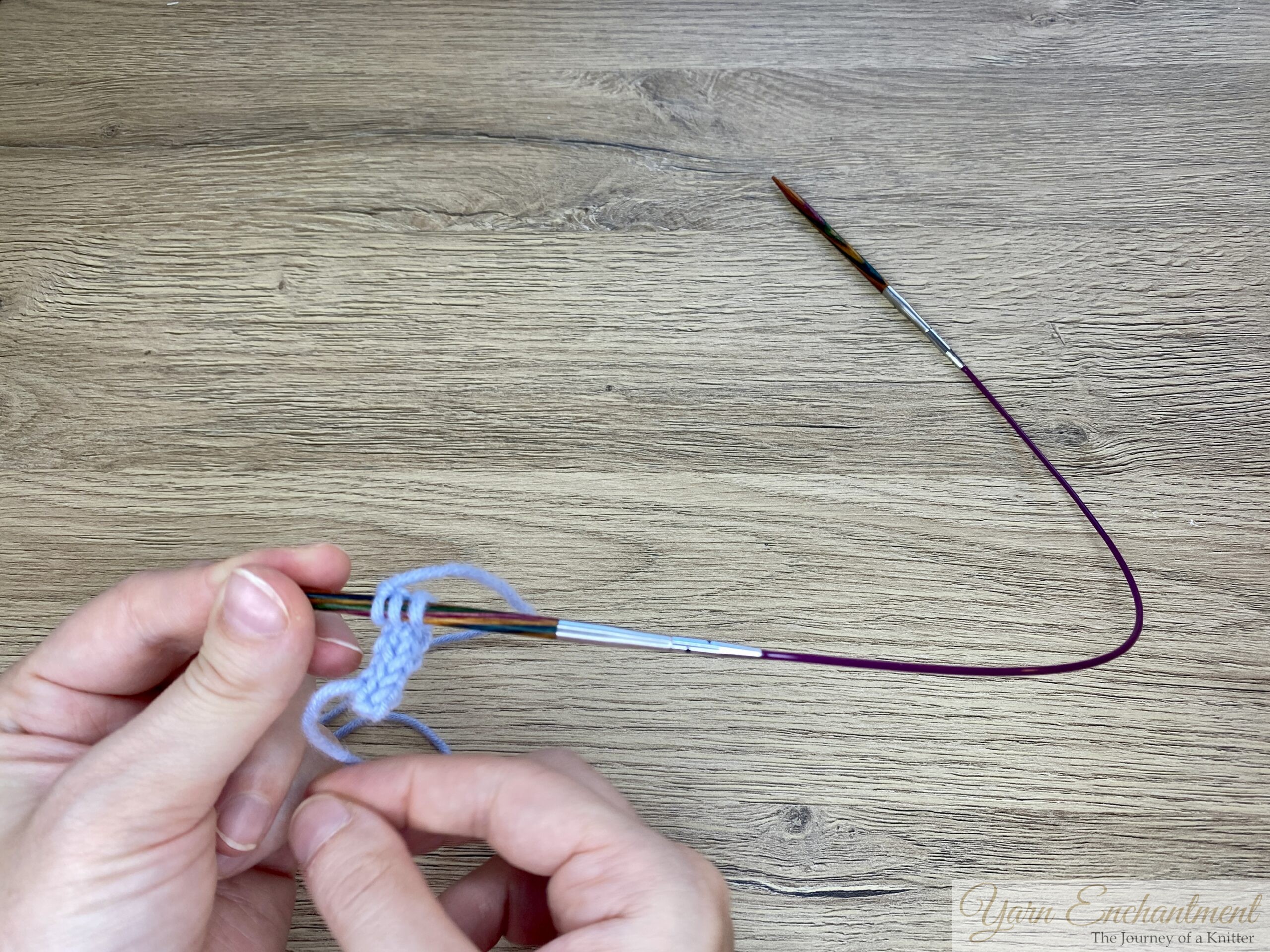 The blue I-cord stitches have been slid onto the colorful needle tip of the circular needle, ready for the next row to be worked.