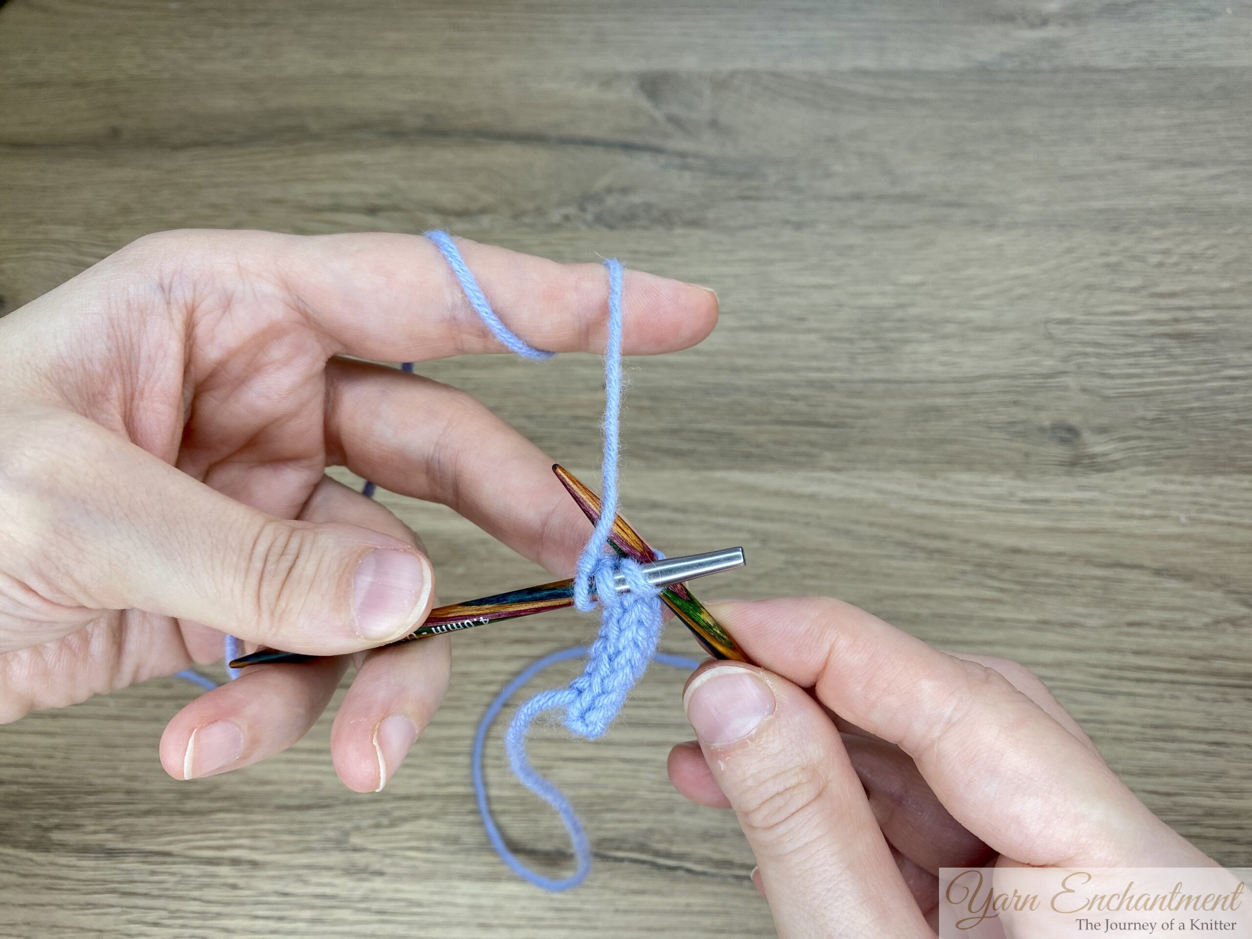 A demonstration of knitting I-cord using the tips of interchangeable needles. The images show blue yarn with stitches distributed along colorful needle tips, step by step, illustrating how to slide the stitches from one tip to the other to continue knitting the I-cord.
