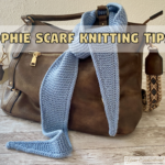 A light blue knitted Sophie scarf draped around the handle of a brown leather handbag on a rustic wooden table. A text banner above the scarf reads "Sophie Scarf Knitting Tips."