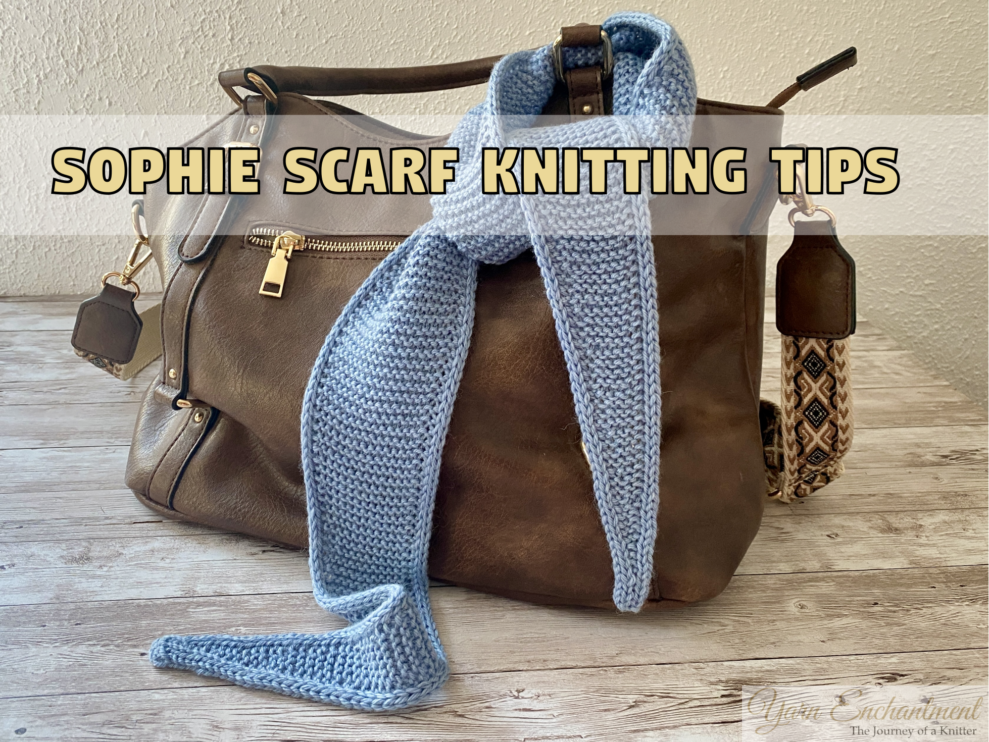 A light blue knitted Sophie scarf draped around the handle of a brown leather handbag on a rustic wooden table. A text banner above the scarf reads Sophie Scarf Knitting Tips.