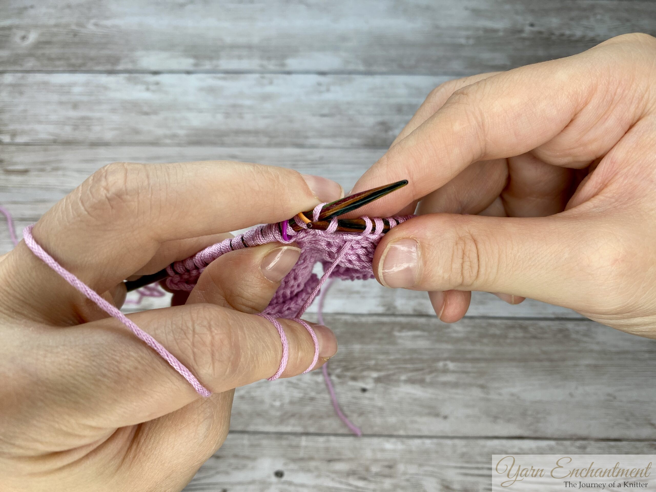 Knitting needle tip inserted into the back loop of the stitch from the left, ready to wrap yarn to close the yarn-over gap.