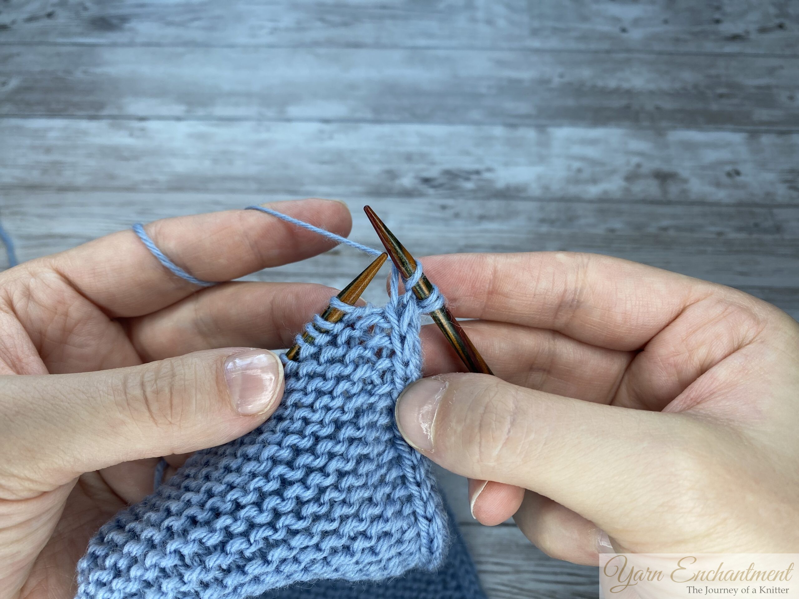 A three-part close-up sequence showing hands working a decrease stitch on a light blue knitted Sophie scarf. The photos show the right-hand needle inserting into stitches, wrapping the yarn, and pulling the new loop through to complete the decrease.