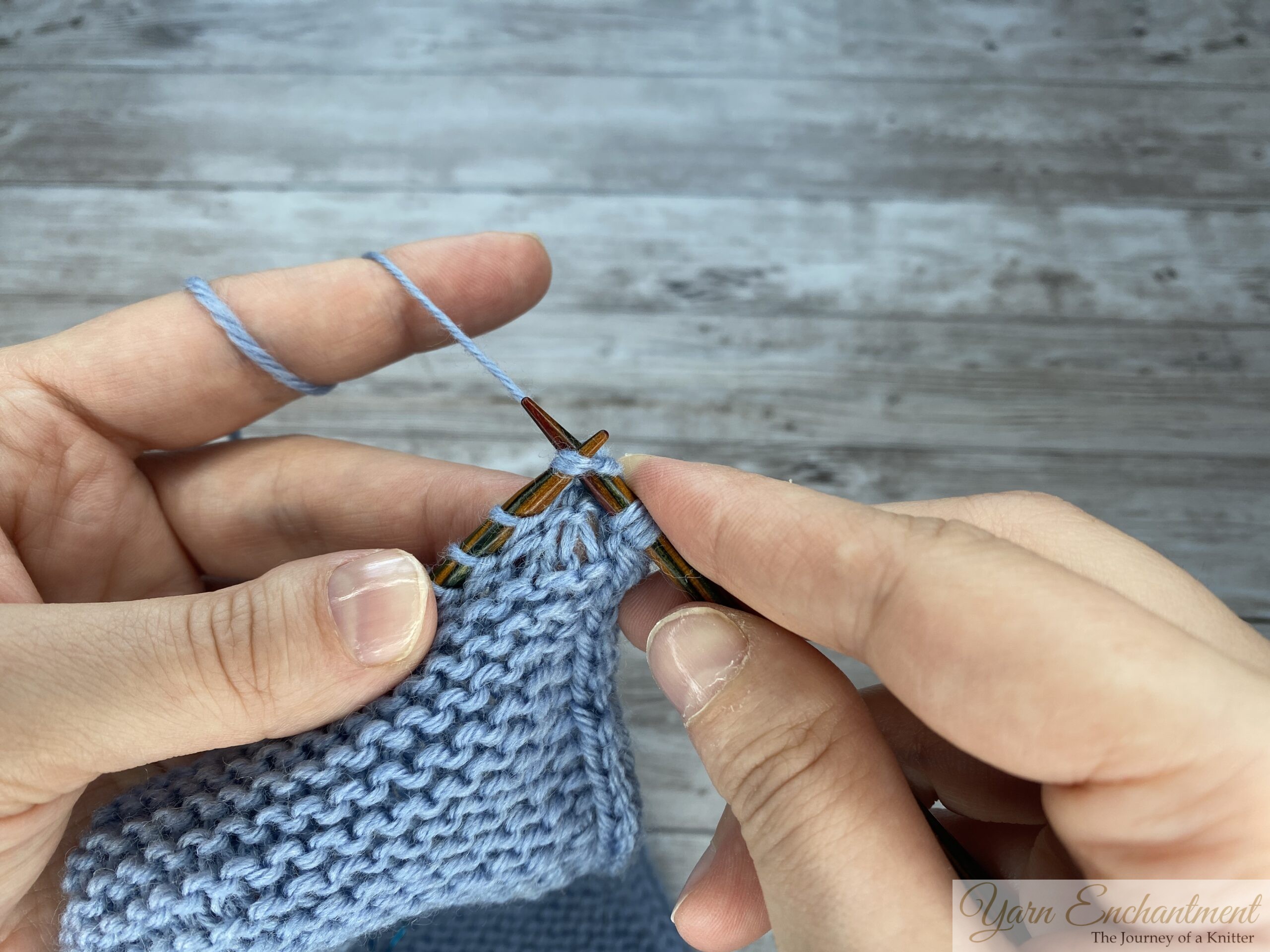 A three-part close-up sequence showing hands working a decrease stitch on a light blue knitted Sophie scarf. The photos show the right-hand needle inserting into stitches, wrapping the yarn, and pulling the new loop through to complete the decrease.