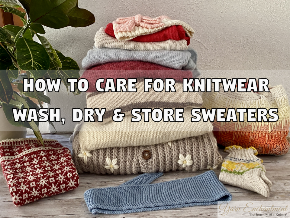 A cozy stack of folded knitted sweaters in various colors (red, pink, blue, cream) sits on a wooden floor next to a green potted plant. Scattered around the stack are knitted accessories, including a red and white patterned hat, a blue scarf, and small mittens. Large text overlays the image reading: 'HOW TO CARE FOR KNITWEAR' and 'WASH, DRY & STORE SWEATERS'.