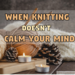 A cozy arrangement of thick tan yarn, wooden knitting needles, a soft white knitted blanket, pinecones, and two lit tealight candles resting on a wooden board, overlaid with the text "WHEN KNITTING DOESN'T CALM YOUR MIND