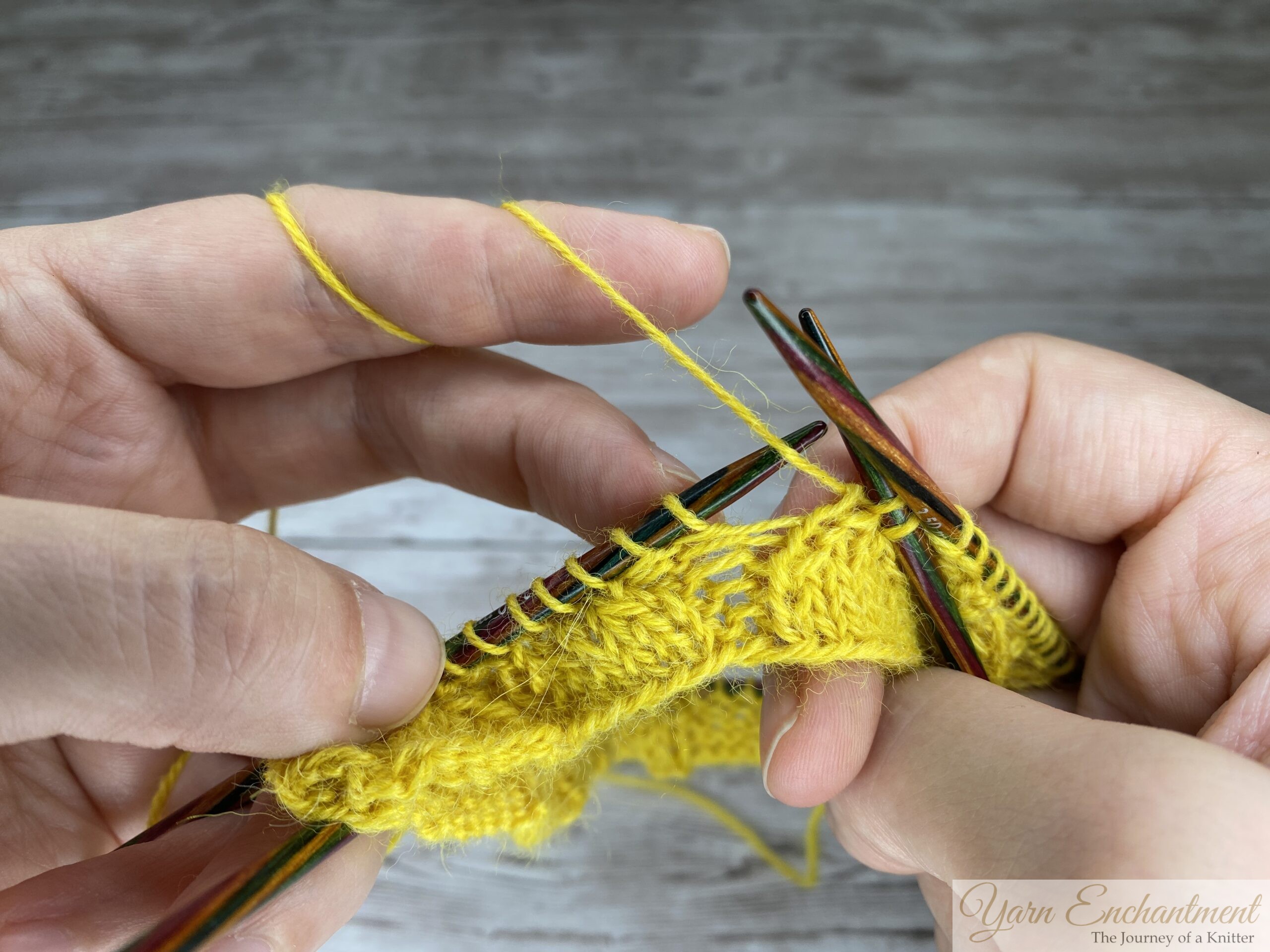 A close-up detail of a decrease stitch being completed. The rig